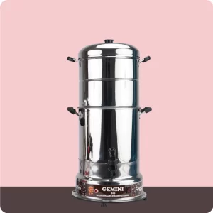 A tall, stainless steel traditional filter coffee maker with multiple compartments and handles, labeled Gemini, stands against a pink and brown background 1.